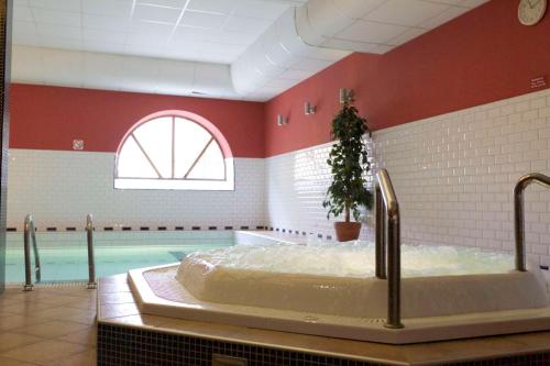 a large swimming pool with a tub in a room at Scandic Arvika in Arvika