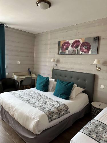 a hotel room with a large bed with blue pillows at La Bonbonniere - Sure Hotel Collection by Best Western in Talant