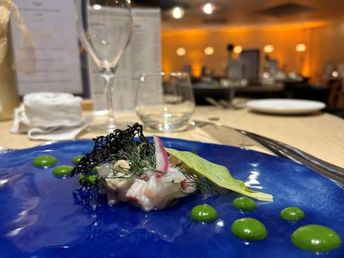 a blue plate with food on a table at Best Western Plus Le Roi Arthur Hôtel & Spa in Ploërmel