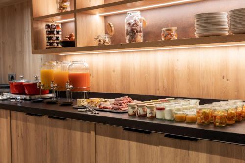 a buffet line with many different types of drinks at Best Western Plus Le Roi Arthur Hôtel & Spa in Ploërmel