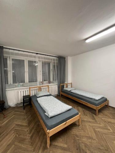 two beds in a room with two windows at Nice flat in City Center Kraków in Krakow