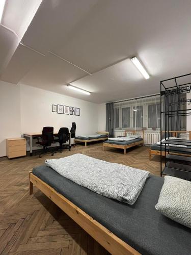 a bedroom with two beds and a desk and chairs at Nice flat in City Center Kraków in Krakow