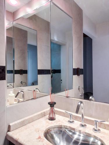 a bathroom with a sink and a large mirror at DeptoViamonte - 2 Dormitorios, Terraza y Cochera in Córdoba