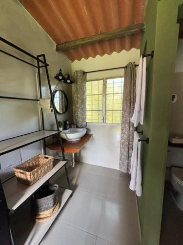a bathroom with a sink and a toilet and a window at La Quinta del Valle in Llano Grande