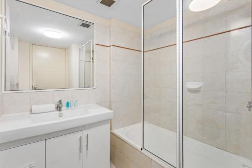 a bathroom with a shower and a sink and a tub at Albion Convenient Hideaway with Parking & Balcony in Brisbane