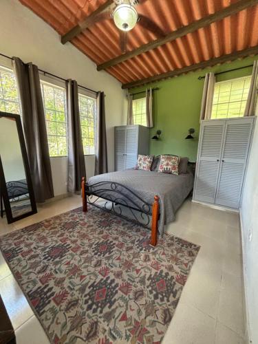 1 dormitorio con cama y alfombra en La Quinta del Valle, en Llano Grande