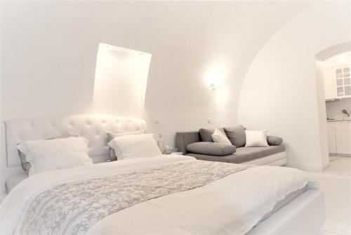 ein weißes Schlafzimmer mit einem Bett und einem Sofa in der Unterkunft Unique XVI century Old Town Apartment in Vilnius