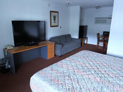 a hotel room with a bed and a tv and a couch at Royal A Motel in Auburn