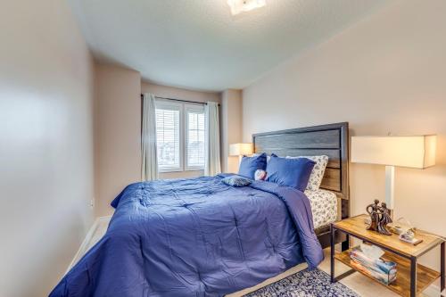 um quarto com uma cama com um edredão azul e uma janela em Avid vacation palace in Castlemore , Brampton em Brampton