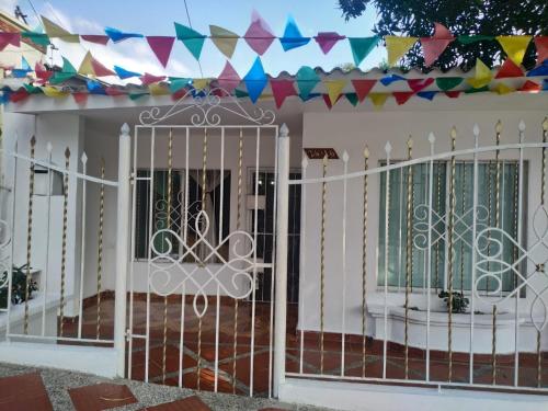 una cerca blanca con una puerta delante de una casa en Habitación Amplia cerca al Éxito de la Cra 27 en Barranquilla