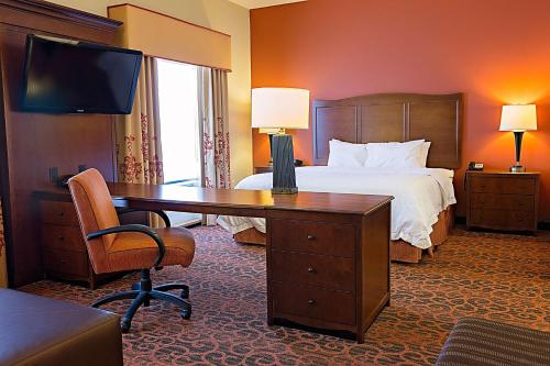 Habitación de hotel con cama y escritorio. en Hampton Inn & Suites Jacksonville, en Jacksonville