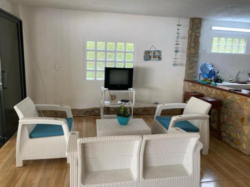uma sala de estar com uma mesa e cadeiras e uma televisão em Gaia - Casa de Playa em San Bernardo del Viento