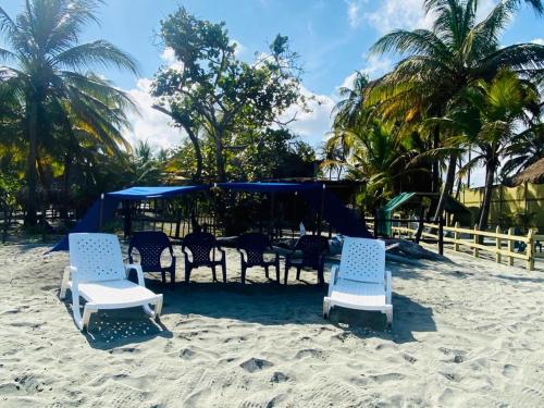 um grupo de cadeiras e mesas na praia em Gaia - Casa de Playa em San Bernardo del Viento
