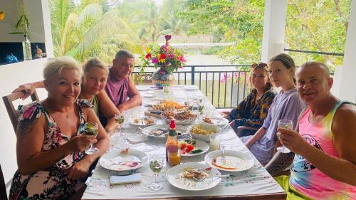 um grupo de pessoas sentadas à volta de uma mesa a comer em Silence Paradise em Tangalle