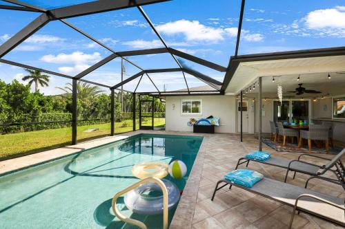 une piscine intérieure avec un grand plafond en verre dans l'établissement Spacious Home & Lanai W/Heated Saltwater Pool!, à Cape Coral