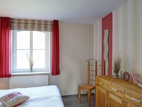 a bedroom with a bed and a window and a wooden dresser at Holiday apartment "Kati" in Lancken-Granitz