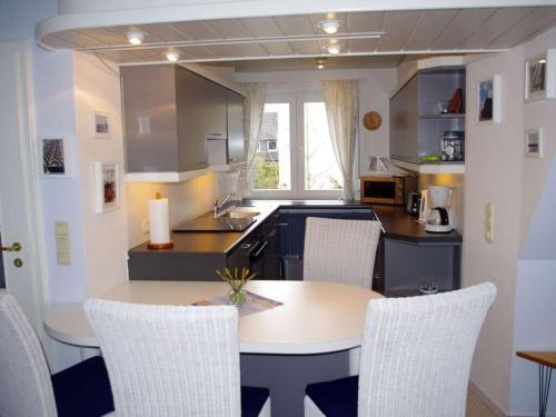 a kitchen with a table and chairs in a room at Apartment in Lower Saxony in Halstenbek