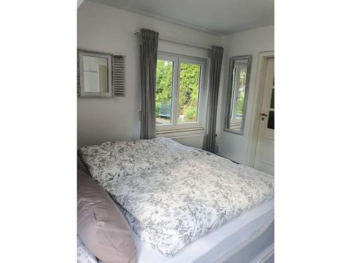 a bedroom with a bed and two windows at Apartment in Lower Saxony in Halstenbek