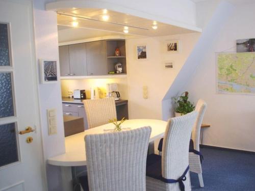 a kitchen with a table and chairs in a room at Apartment in Lower Saxony in Halstenbek