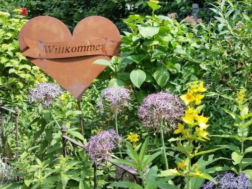 a sign in the middle of a garden with flowers at Apartment in Lower Saxony in Halstenbek