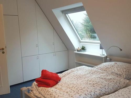 1 dormitorio con 1 cama con manta roja y ventana en Apartment in Lower Saxony, en Halstenbek