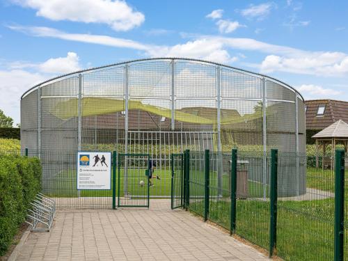 uma gaiola de rebatidas com um sinal à frente em Beautiful chalet in Middelkerke, 300m from the sea em Middelkerke