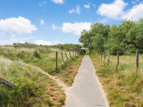 een pad door een veld met een hek bij Beautiful chalet in Middelkerke, 300m from the sea in Middelkerke
