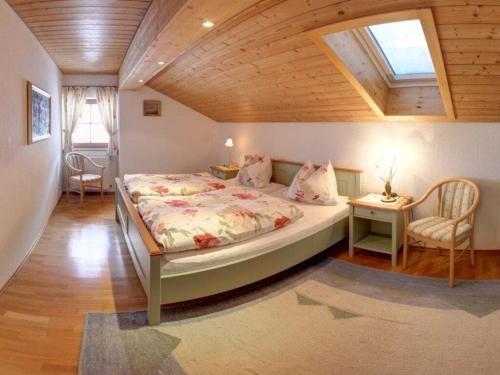 a bedroom with a large bed with a wooden ceiling at Staufenblick roof studio in the house in Inzell
