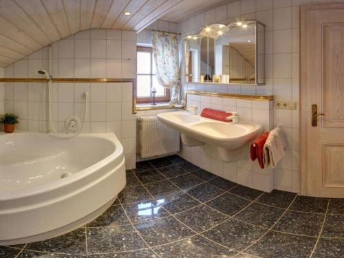 a white bathroom with a tub and a sink at Staufenblick roof studio in the house in Inzell