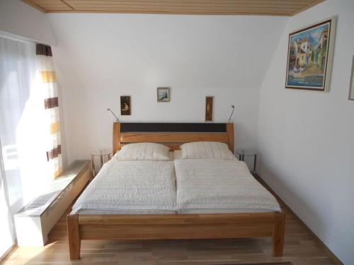 a bed in a white room with two pillows at Apartment with beautiful sea view in Pappenheim