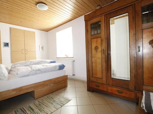 1 dormitorio con 1 cama y armario de madera en Holiday apartment Old Town Hall, en Tauberbischofsheim