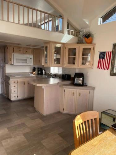 a kitchen with white cabinets and a sink and a table at Sand Castle - Ocean Cabin 25 W Private Jacuzzi in Smith River