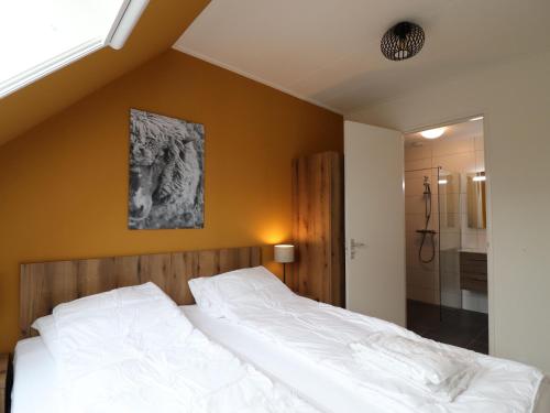 - une chambre avec un grand lit blanc et une douche dans l'établissement Wheelchair accessible villa in Friesland, à Leons