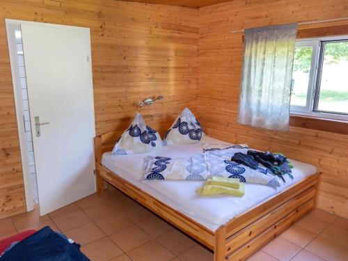 TrattenにあるBungalow in Bodensdorf near Gerlitzen Ski Areaの木製の部屋にベッド1台が備わるベッドルーム1室があります。