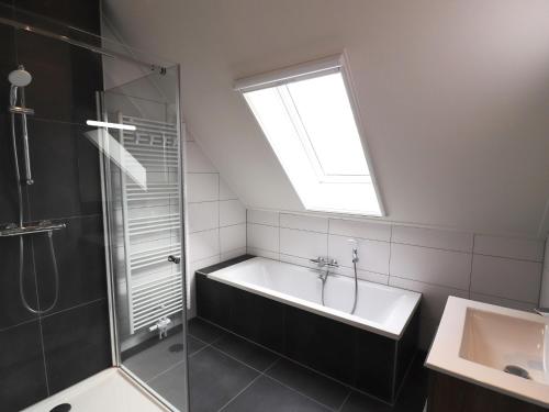 La salle de bains est pourvue d'une baignoire, d'une douche et d'une fenêtre. dans l'établissement Wheelchair accessible villa in Friesland, à Leons