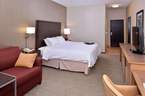 a hotel room with a bed and a couch at Wingate by Wyndham Steubenville in Steubenville