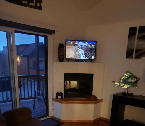 sala de estar con chimenea y TV de pantalla plana en Oceanview Cabin 26 W Jacuzzi & Striking Views, en Smith River