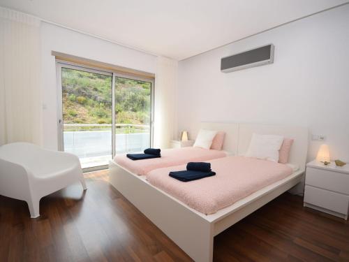 a white bedroom with a large bed and a window at Holiday Home near São Martinho Beach in Salir de Porto