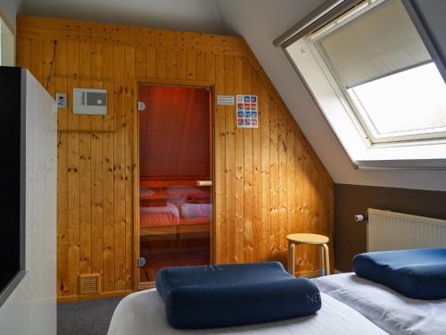 two beds in a room with a skylight at Holiday home with sauna & outdoor spa in Earnewâld in Earnewâld