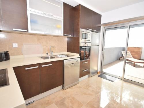 a kitchen with stainless steel appliances and a large window at Holiday Home near São Martinho Beach in Salir de Porto