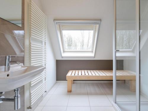 a bathroom with a bench and a sink and a window at Family-Friendly Nature Stay in Earnewâld