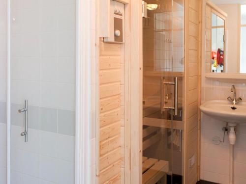 een badkamer met een douche en een wastafel bij Luxury home with sauna and outdoor spa in Earnewâld