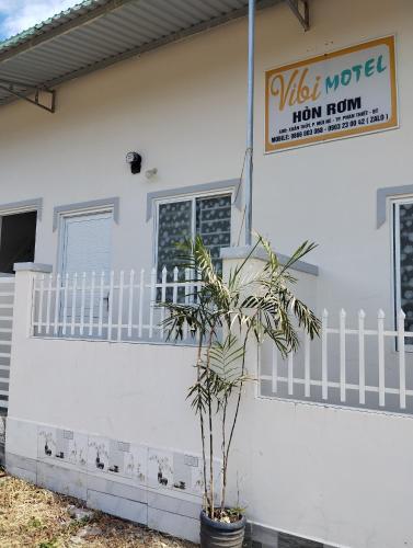 a white house with a plant in front of it at Vibi motel in Phan Thiet