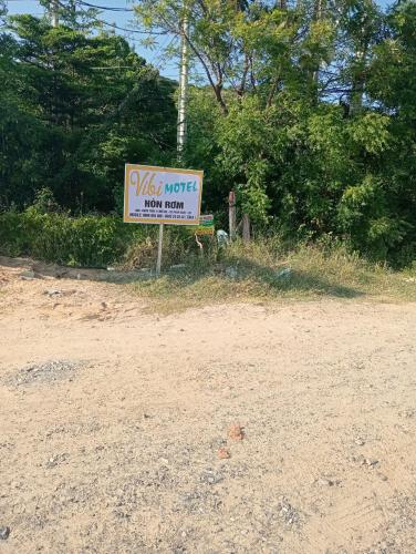 a sign on the side of a dirt road at Vibi motel in Phan Thiet