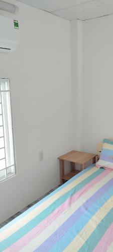 a bedroom with a bed with a colorful rug at Vibi motel in Phan Thiet