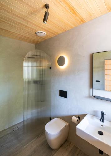 a bathroom with a toilet and a sink and a shower at In The Brick Spa And Hotel in Melbourne