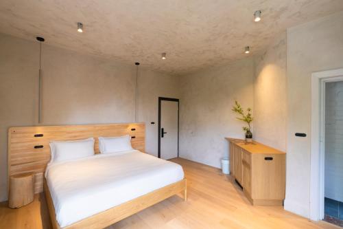 a bedroom with a white bed and a wooden cabinet at In The Brick Spa And Hotel in Melbourne
