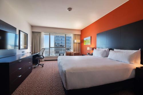 Cette chambre comprend un grand lit et une grande fenêtre. dans l'établissement Hilton Garden Inn Montevideo, à Montevideo