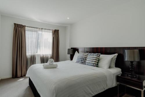 een slaapkamer met een groot wit bed en een raam bij Urban 1-Bed Apartment in the Heart of the City in Canberra