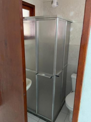 uma casa de banho com uma cabina de duche e um WC. em Pousada Cantinho da Nilza em Cabo Frio